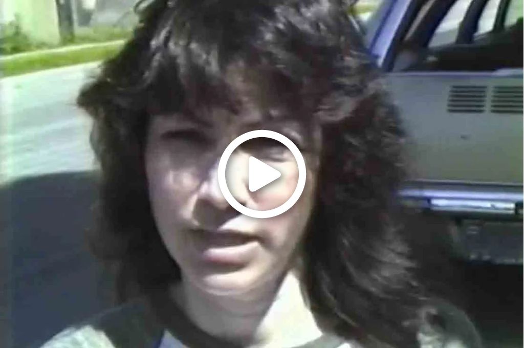 A video still of a young woman talking to the camera. 